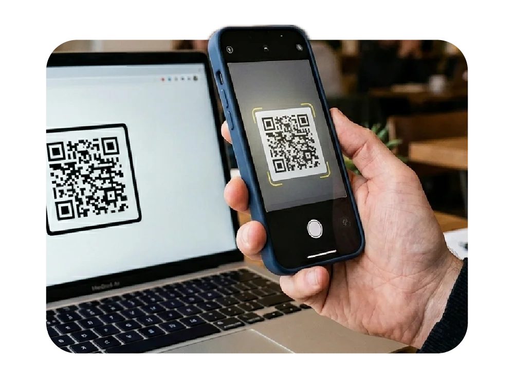 A mobile phone scanning a QR code on a laptop screen
